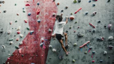 877371188 One young man is enjoying rock climbing in a climbing centre.