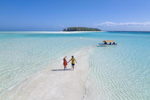 Aerial view of couple walking hand in hand in the exotic lagoon, Zanzibar, Tanzania