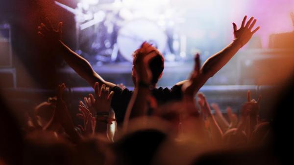 Cheering crowd in front of bright stage lights