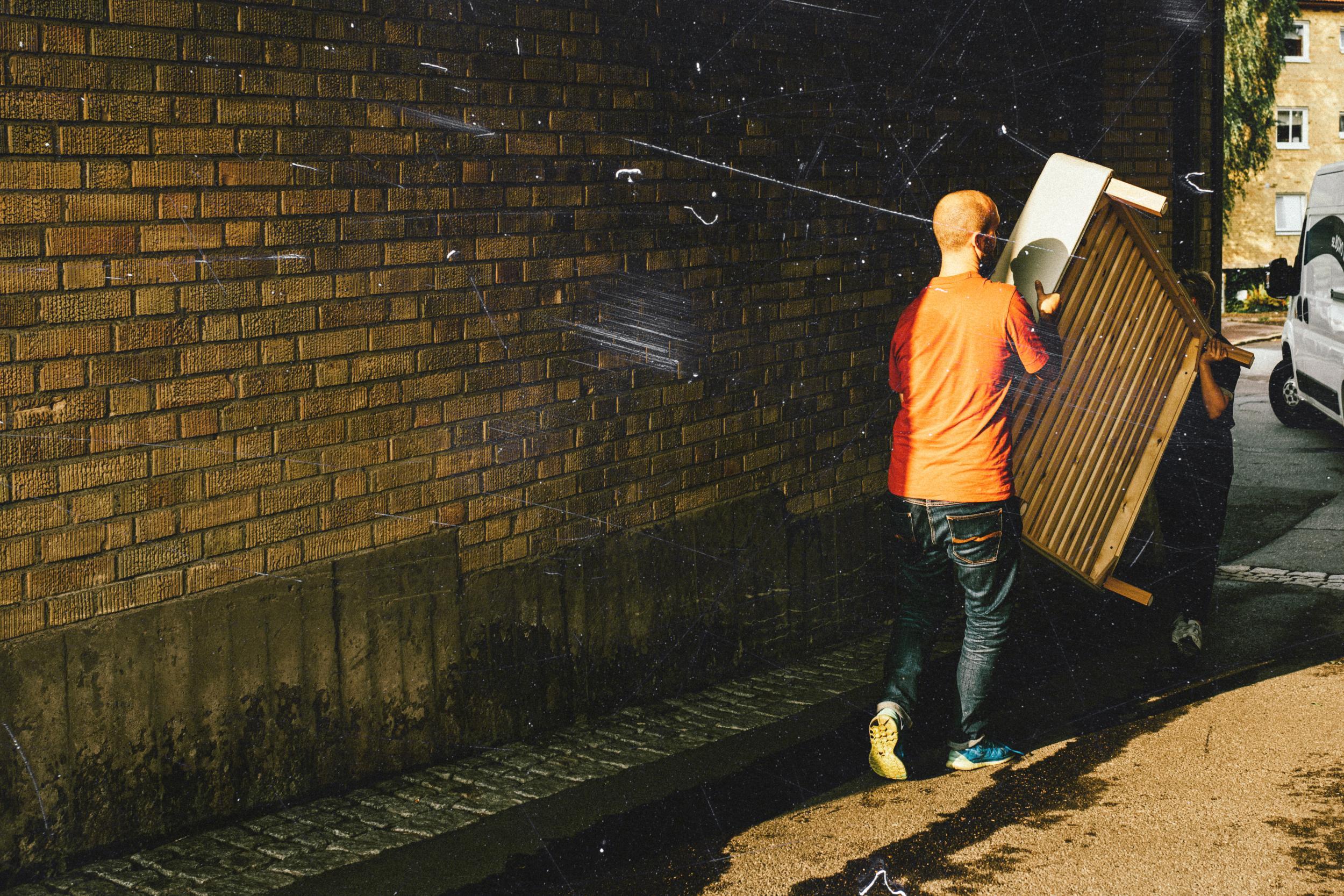 Moving men carry a bed