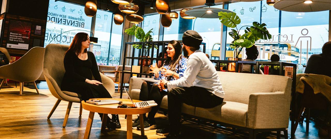 Work Cafe customers sitting down having a conversation.